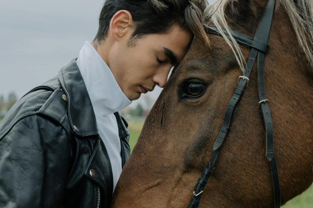 Portrait of a man gently leaning against his horse