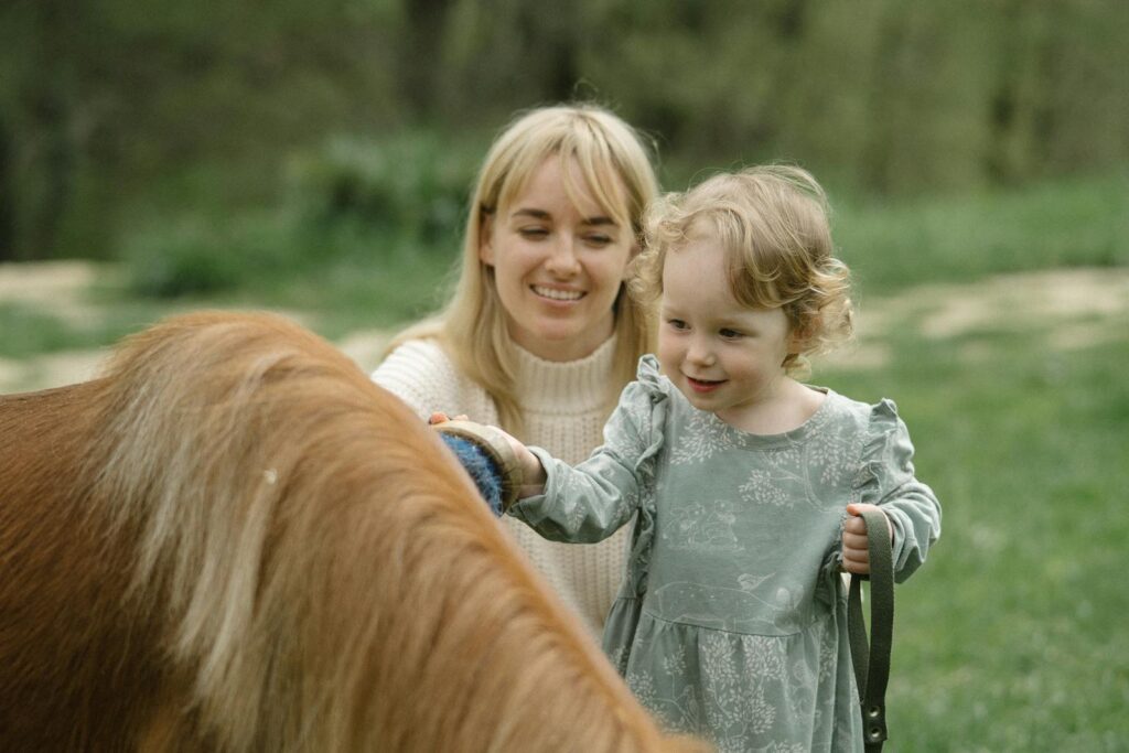 Mother and daughter gently brushing a horse