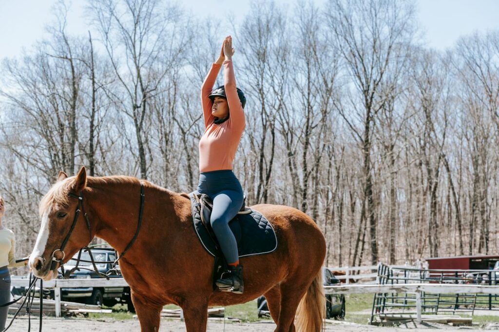 Woman practicing balance exercises on horseback