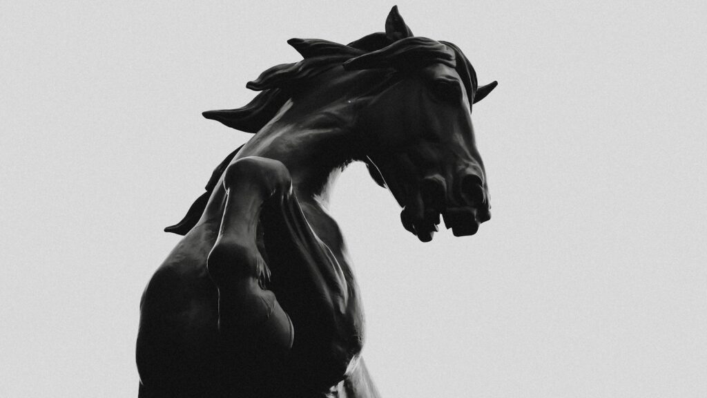 black horse statue in grayscale photography
