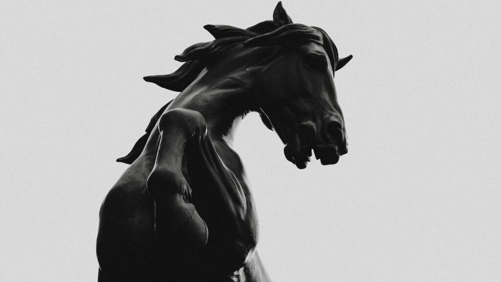 black horse statue in grayscale photography