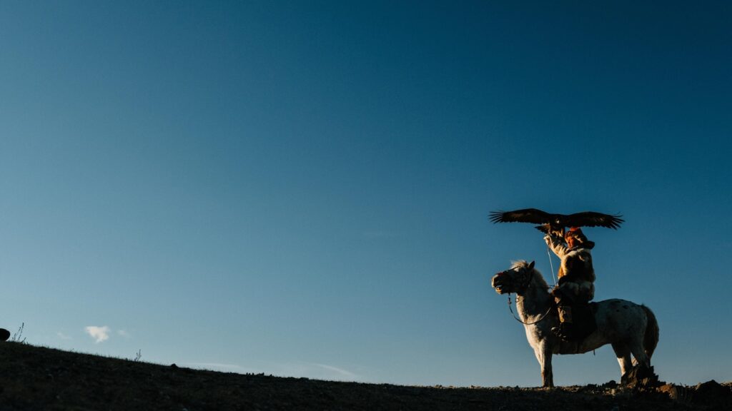A person on a horse with an eagle on its back
