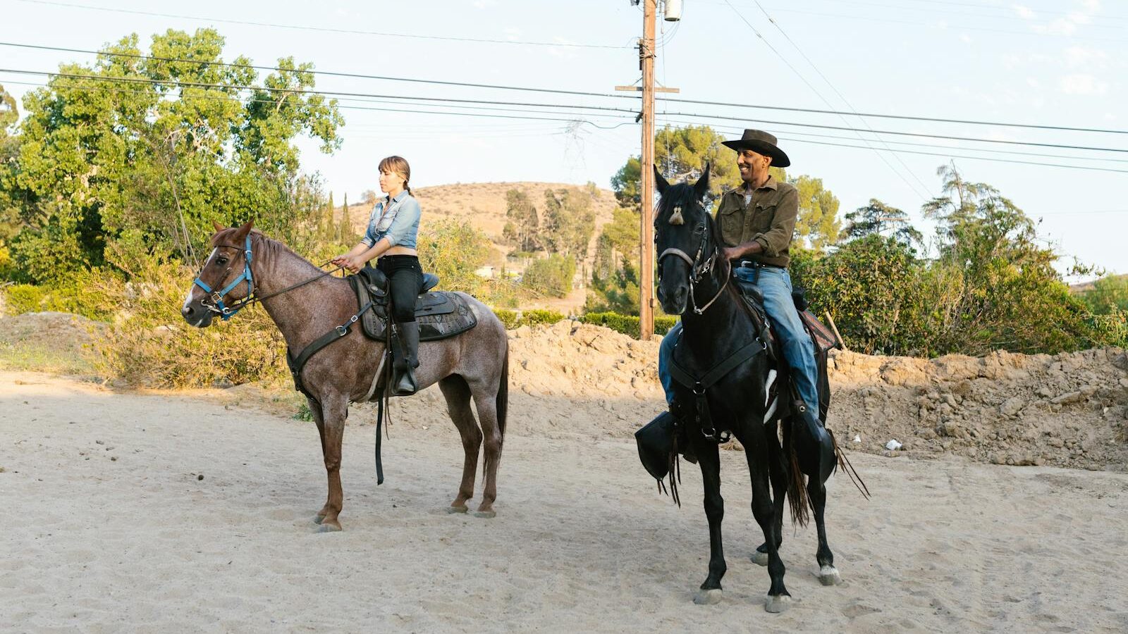 Two people riding horses outdoors, showcasing equestrian lifestyle and nature.