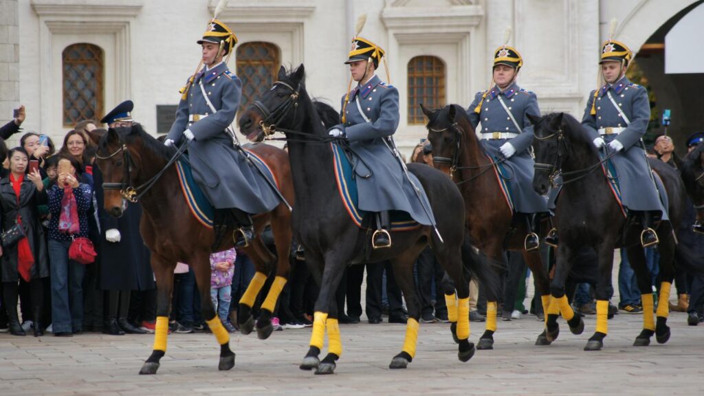 Russian guards on horseback parade outside historic Moscow landmark