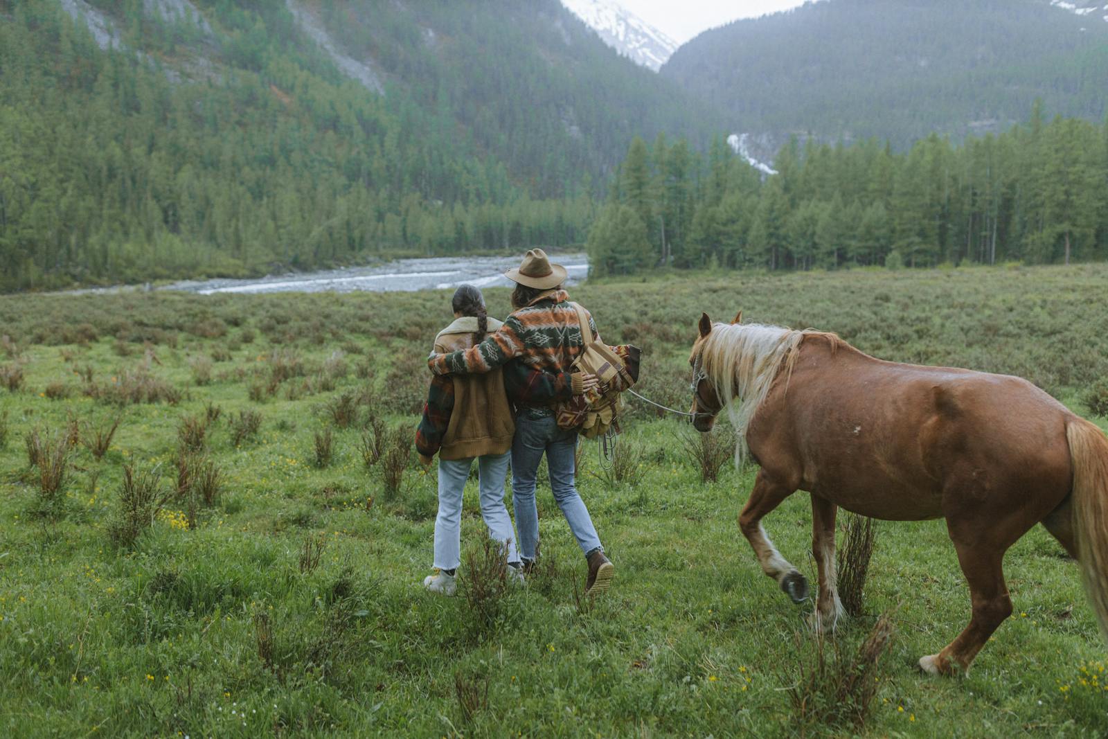 Couple walking with a horse on a scenic mountain trail