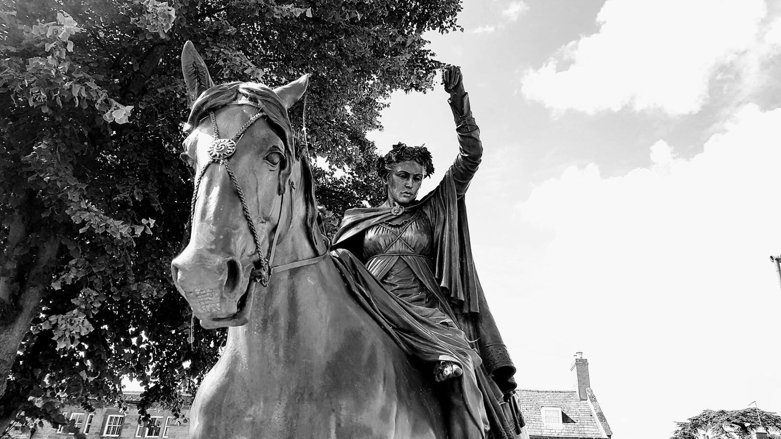A dramatic black and white photo of an equestrian statue, capturing historical elegance and strength.