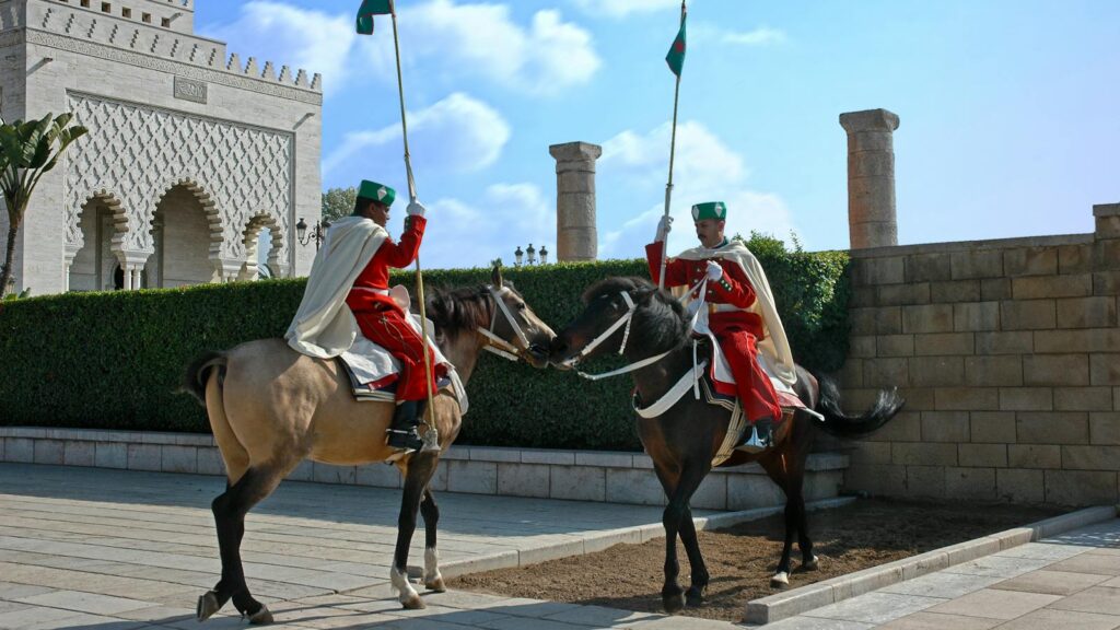 Royal guards on horseback in traditional uniforms at the mausoleum in Rabat, Morocco.