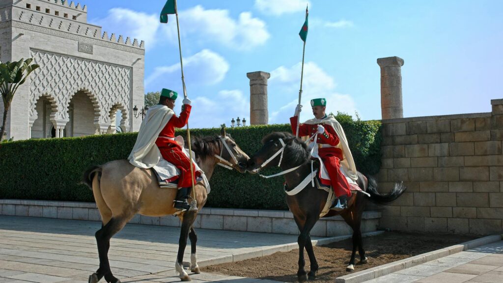 Royal guards on horseback in traditional uniforms at the mausoleum in Rabat, Morocco.