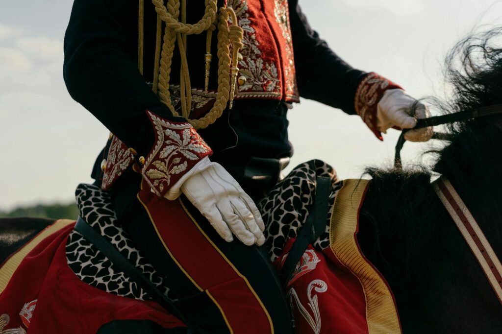Close-up of a traditional hussar cavalry uniform with intricate details, mounted on a horse outdoors.