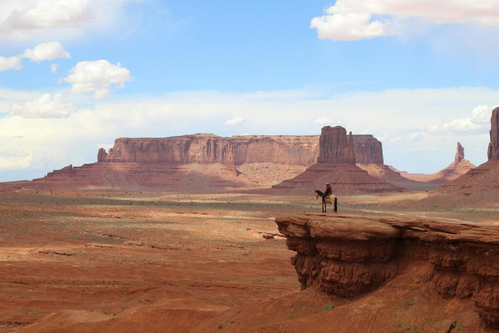 Lone rider on horseback atop a cliff