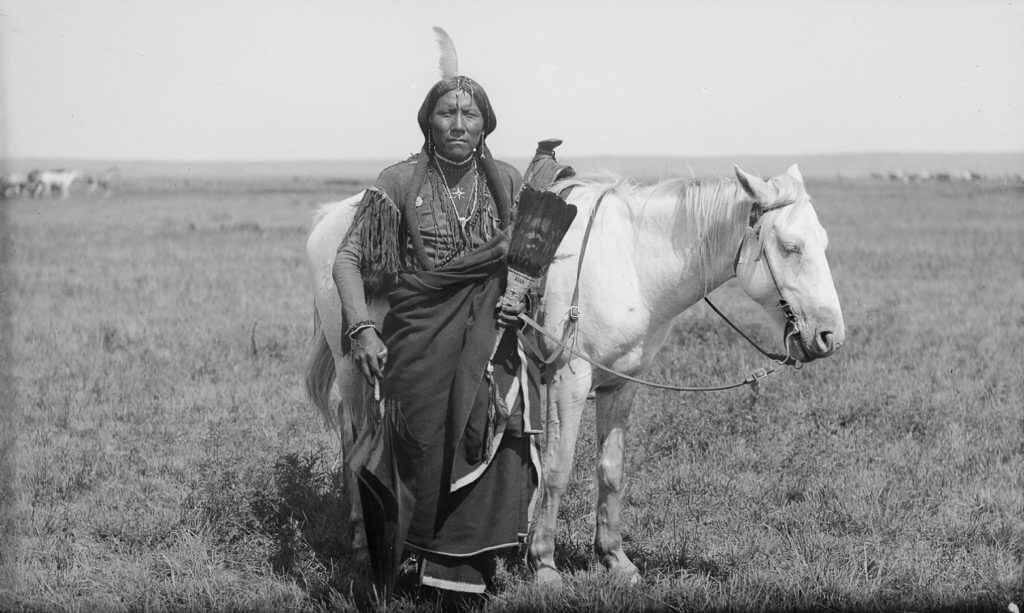 A Comanche warrior named "Ako" and his horse, photographed 1892