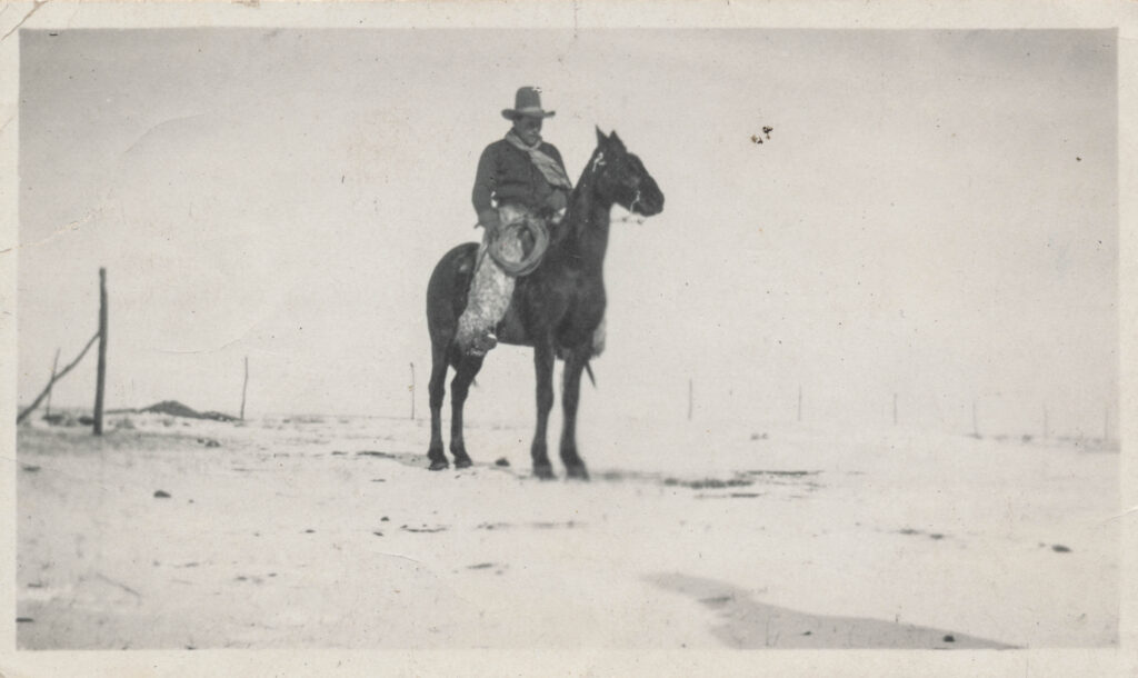 Cowboy riding his horse in an empty field