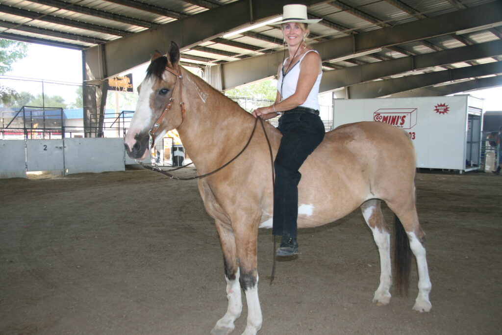 Proud mustang owner shows off how gentle she is by riding bareback at the Western Idaho Fair