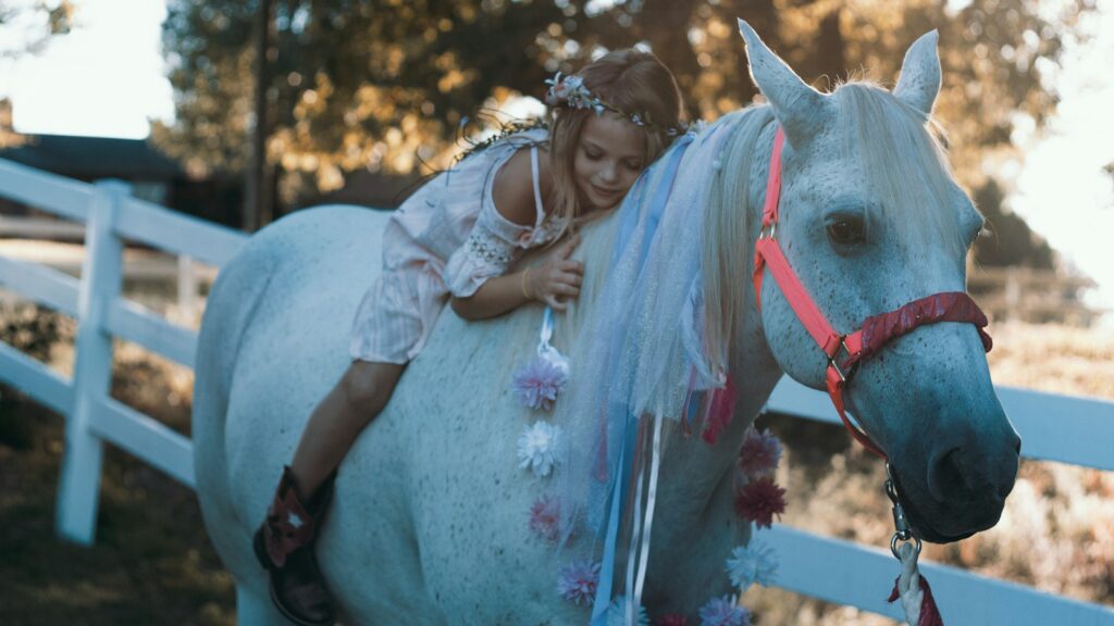 girl riding white horse during daytime