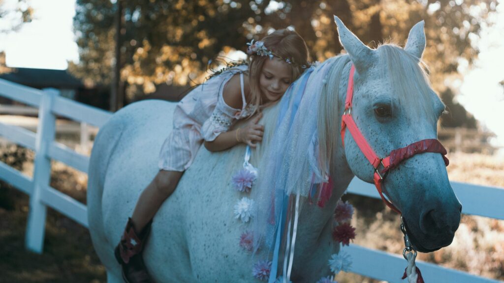 girl riding white horse during daytime