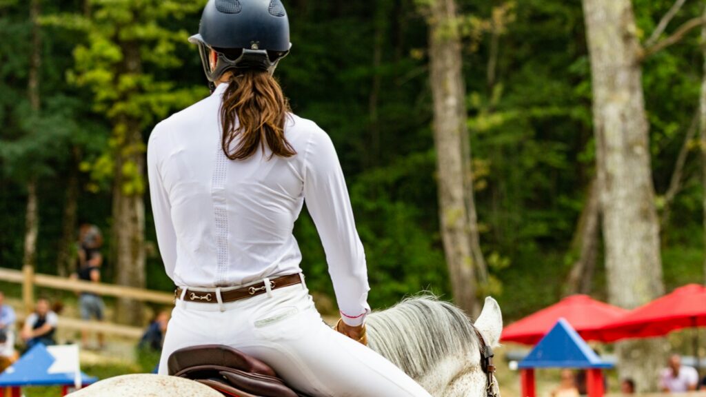 woman in white long sleeve shirt and brown skirt sitting on brown rock during daytime
