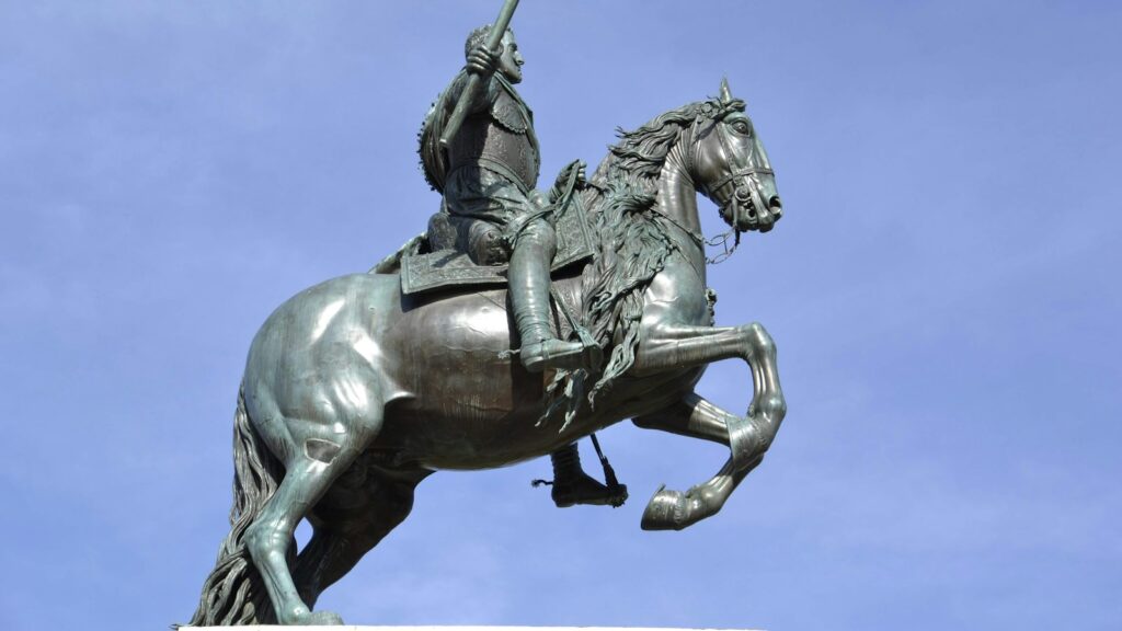man riding on horse statue under blue sky