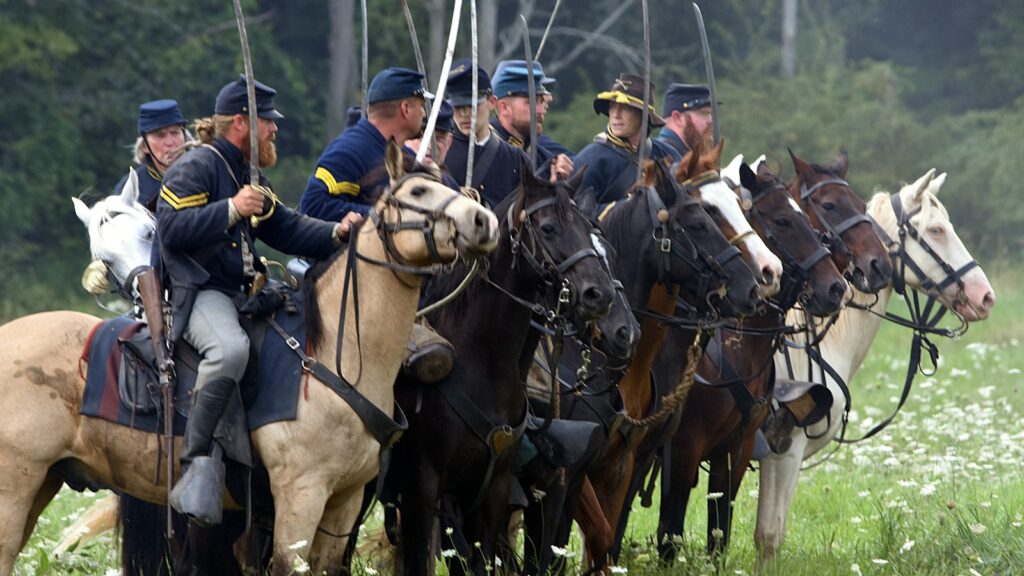 men riding horses on green grass field during daytime