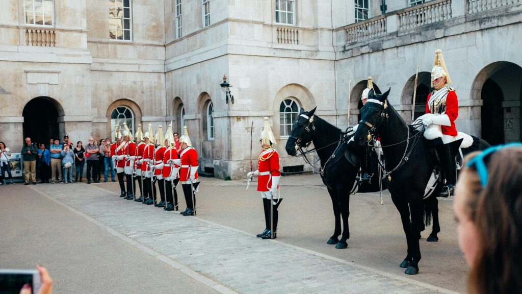 people in red and white uniform riding black horse during daytime