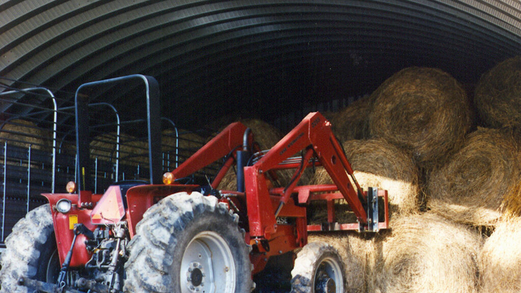 tractors working on stacks of hay