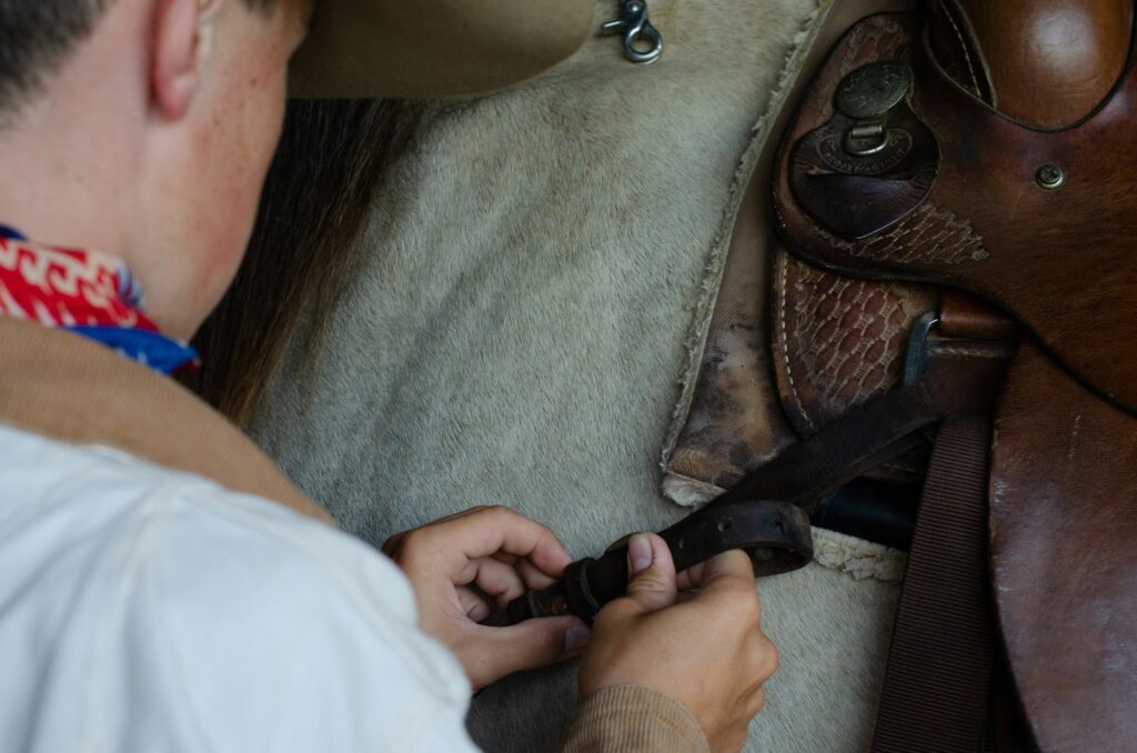 A man seddling up a horse