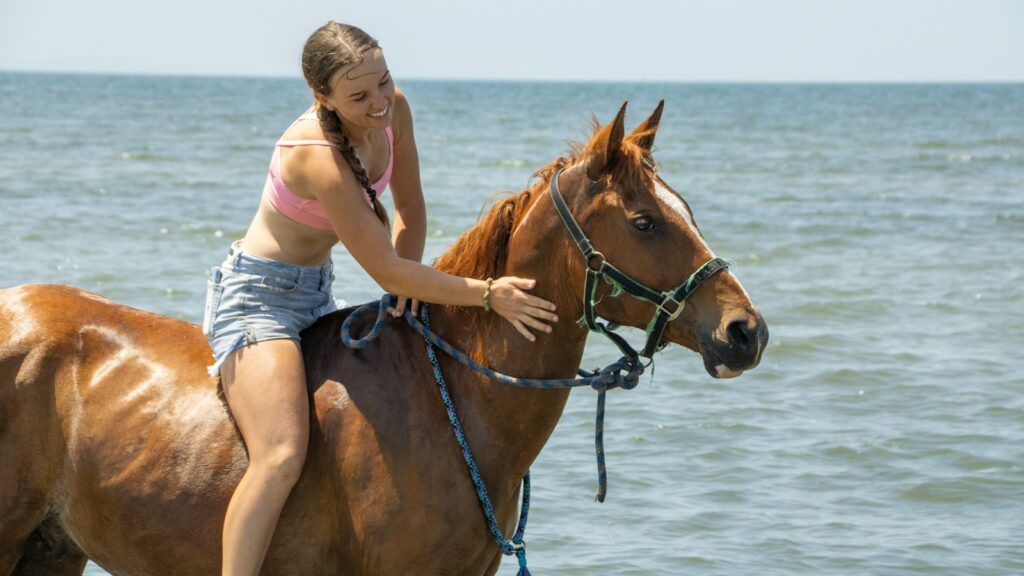 A woman riding on the back of a brown horse