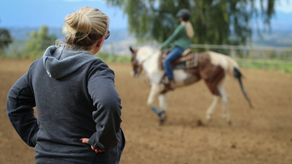 Woman watching man riding horse