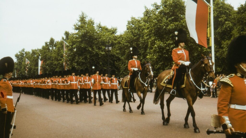 people in red and black uniform riding horses during daytime