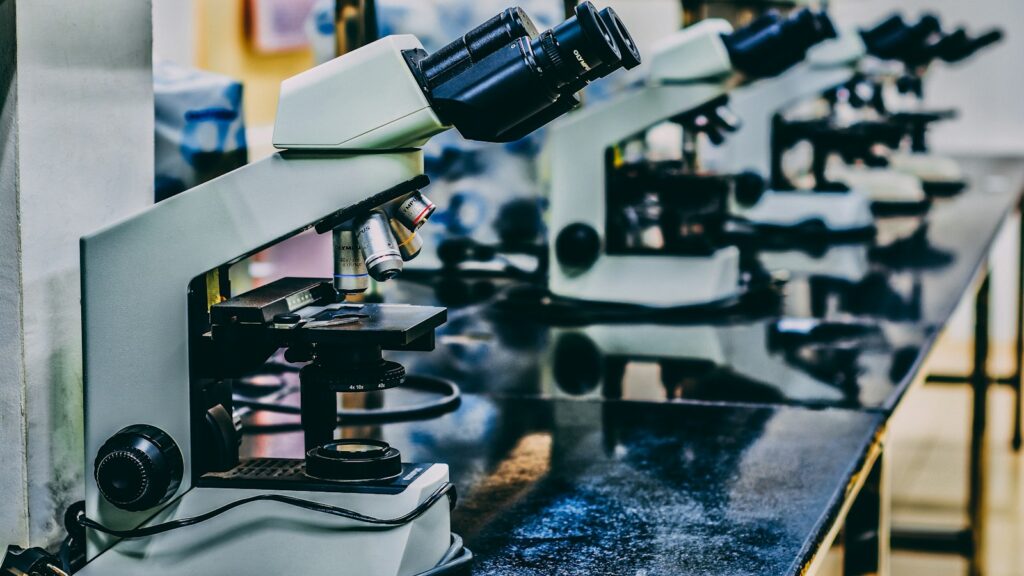 white microscope on top of black table