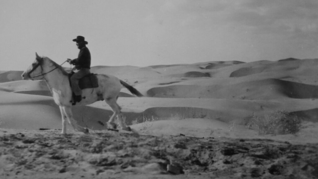 man riding horse on desert