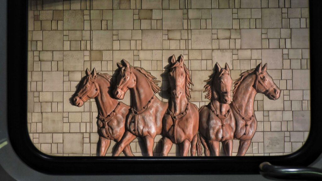 a group of horses standing next to a brick wall