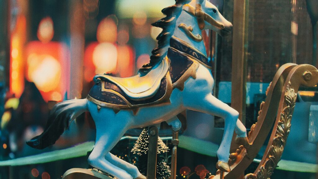 selective focus photo of blue horse carousel