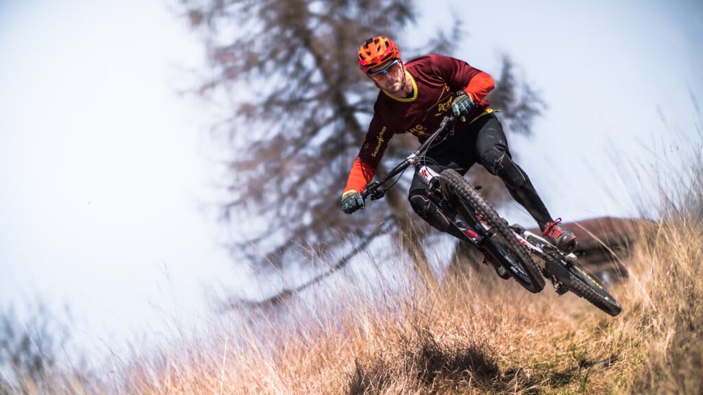 man riding bicycle on brown grass in the daytime