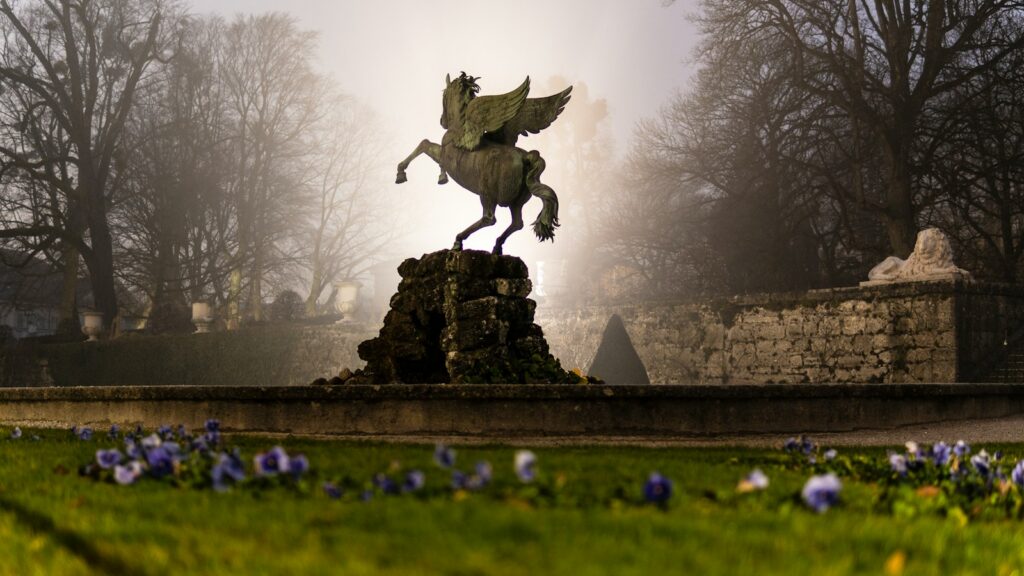 man riding horse statue on green grass field during daytime