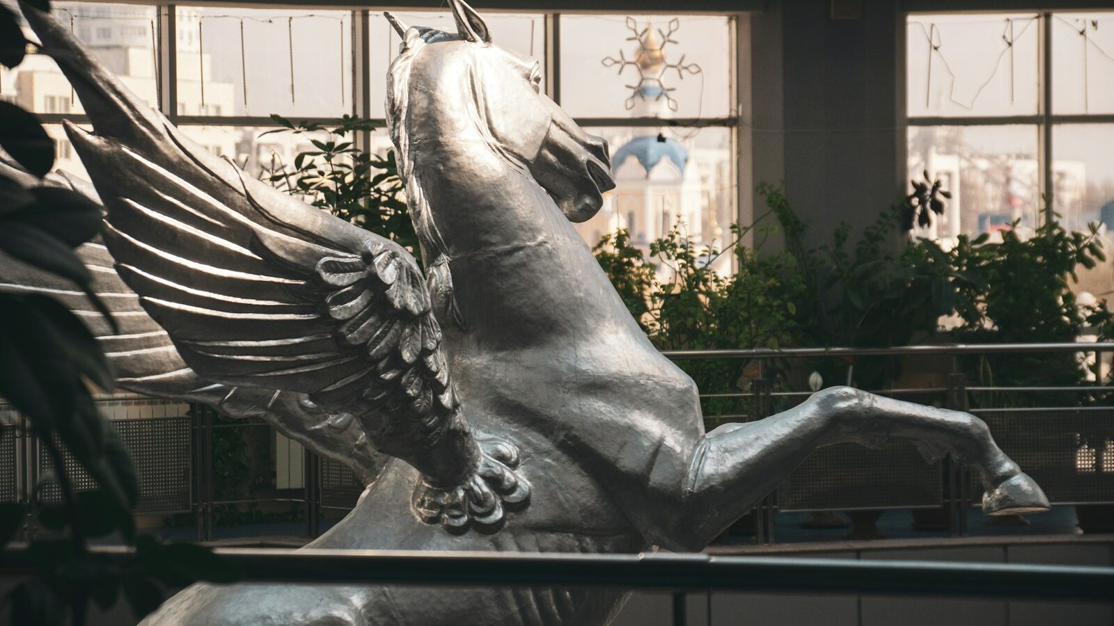A silver pegasus statue stands tall and proud.