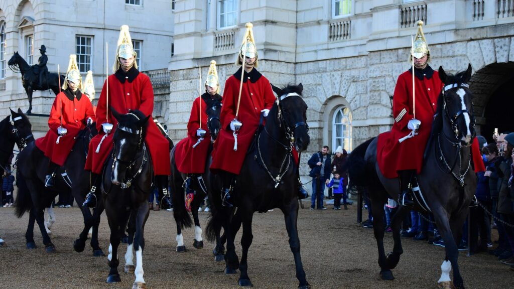man wearing red coat riding horses during daytime