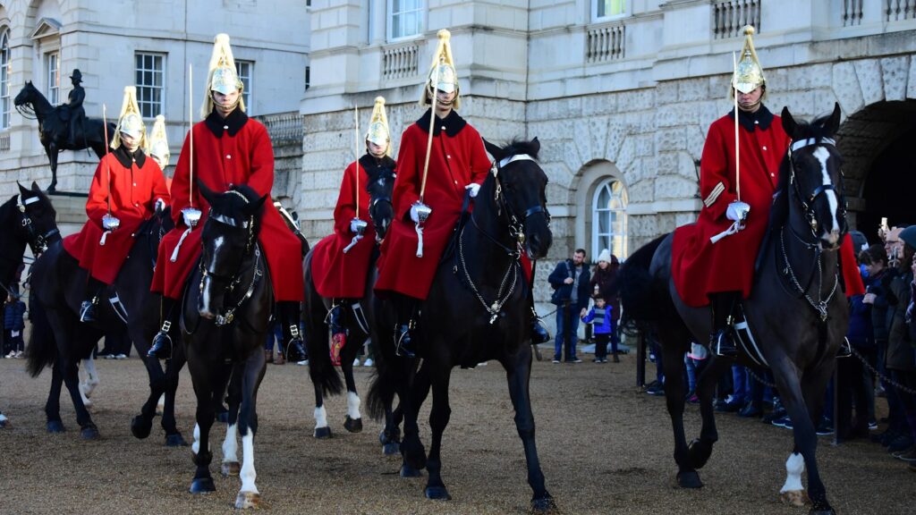 Man wearing red coat riding horses during daytime
