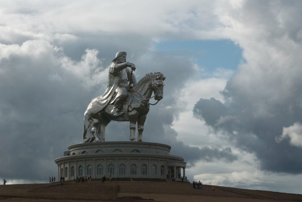 Ghengis Kan riding horse statue under cloudy sky during daytime