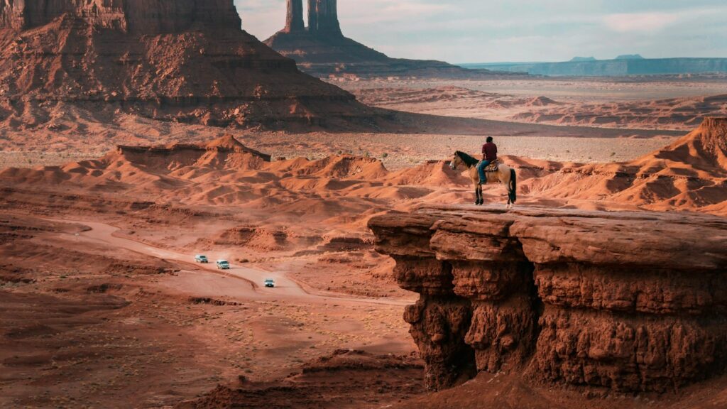 person riding on horse near cliff
