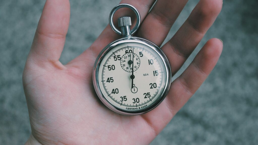person holding white and silver-colored pocket watch