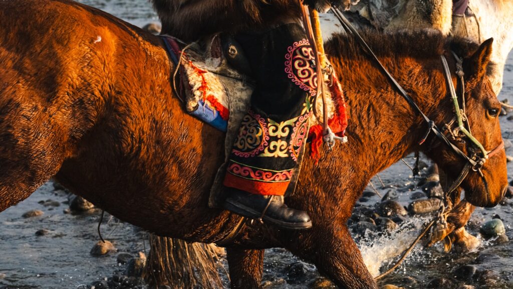 A person rides a horse through water.
