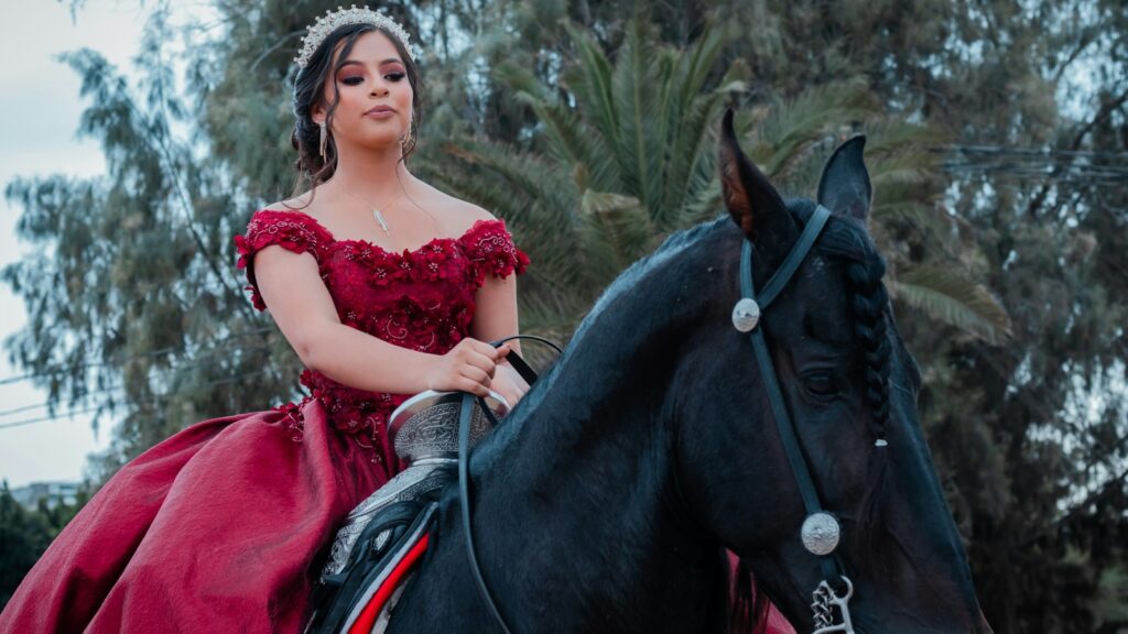 a person in a red dress riding a black horse