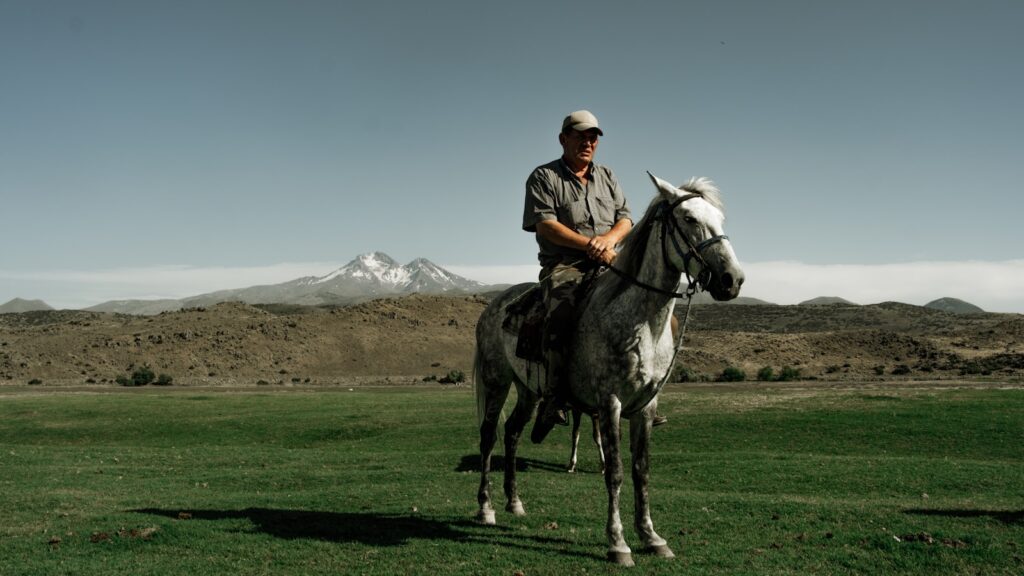 A man riding on the back of a black and white horse
