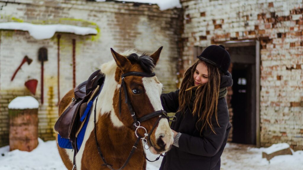 woman holding brown horse's bridle