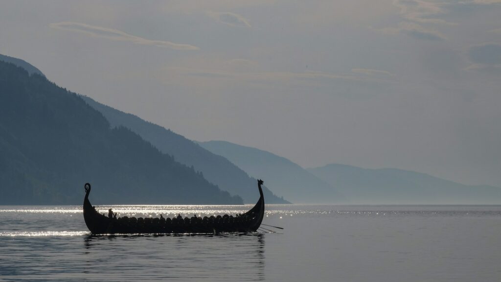 a long boat with two people in it on a lake