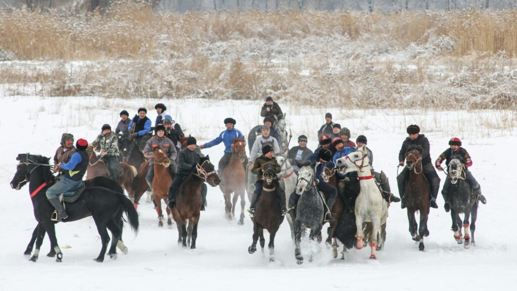 people riding horses on snow covered ground during daytime