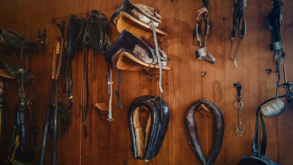 brown leather saddles on brown wall