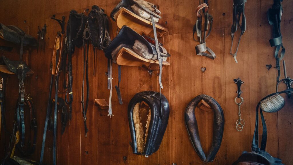 Brown leather saddles on a brown wall