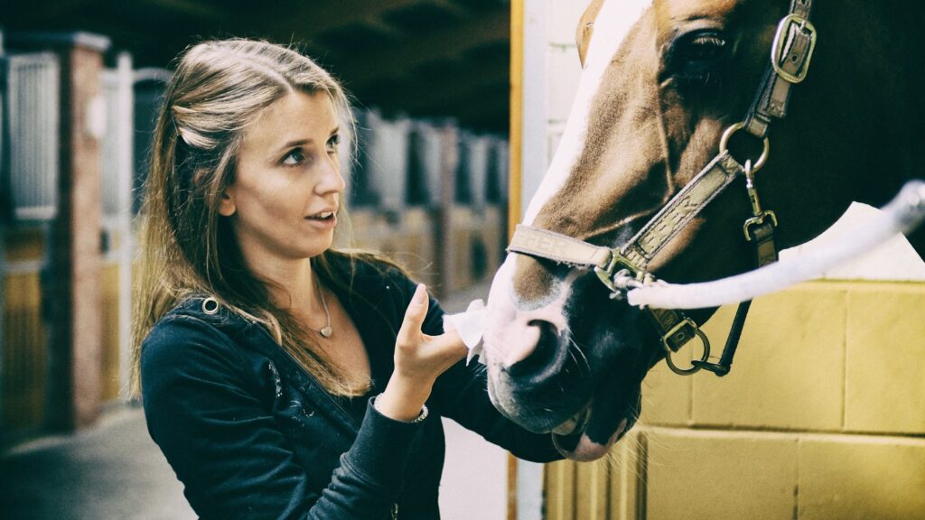 woman in black long sleeve shirt holding white horse head during daytime