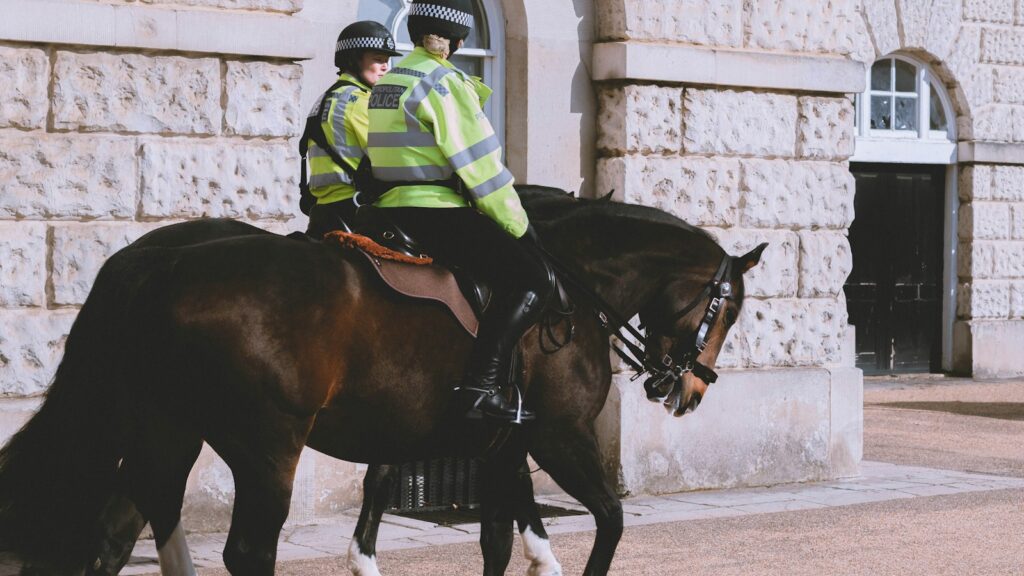 Two mounted police officers on horses in front of a building